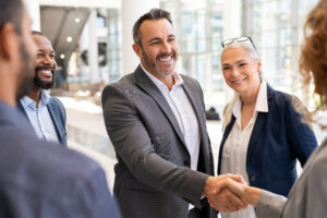 Business people shaking hands in Custom Development Solutions meeting for effective solicitations