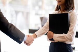 Two businesspeople shaking hands on a business deal after deferring a gift. Custom Development Solutions