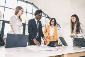 A group of four business people discussing a successful solicitation.