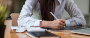 Business woman taking notes on campaign progress reports at Custom Development Solutions