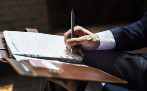 Businessman taking notes for an apology letter with insight from Custom Development Solutions