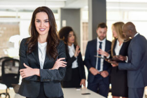 Businesswoman embodying strong leadership in front of a team at Custom Development Solutions.