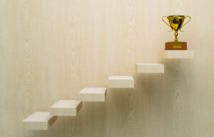 A staircase leading to a gold trophy representing your capital campaign goals.