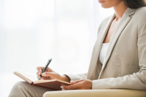 Businesswoman in suit drafting a case statement at Custom Development Solutions.