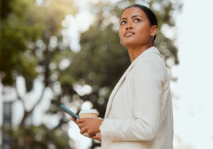 Young businesswoman looking pensive while holding a coffee and thinking about the Rule of Thirds.