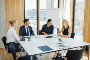 Four people having a campaign report meeting in a conference room at Custom Development Solutions