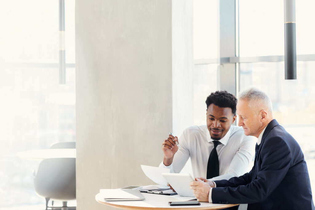 Two businessmen and colleagues reading over the 6 parts of an effective fundraising offer.