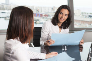 A nonprofit treasurer consulting with another board member in a meeting room.