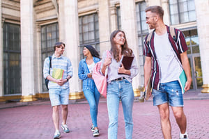 Four students walking on a college campus.